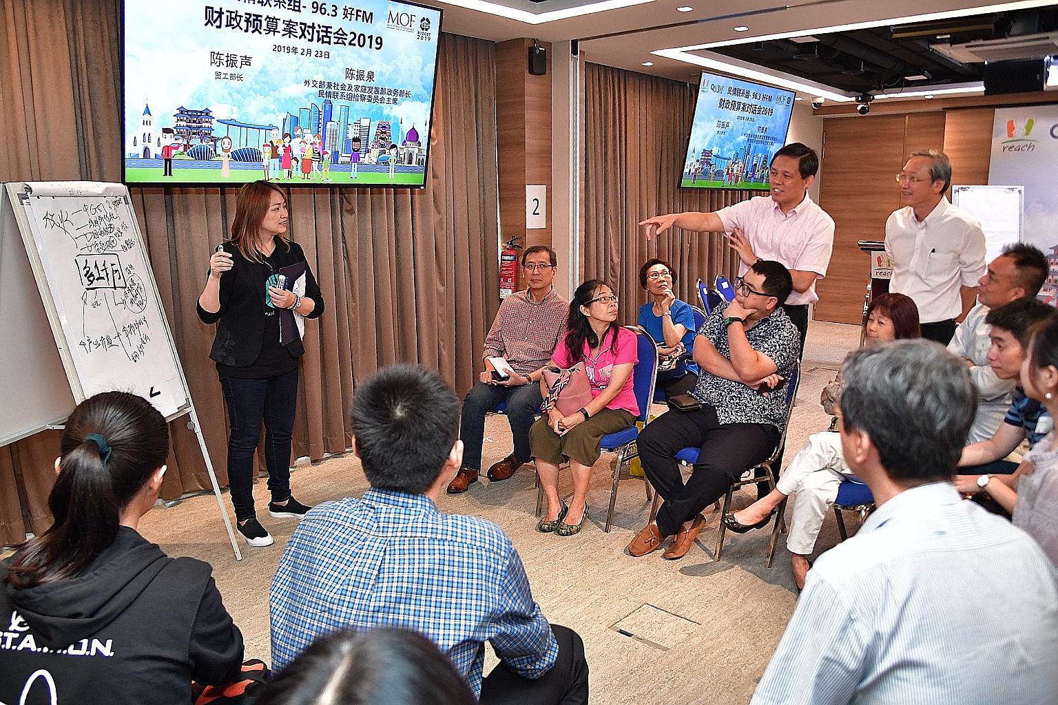 Minister for Trade and Industry Chan Chun Sing with Mr Sam Tan (standing), Minister of State for Social and Family Development and Foreign Affairs and chairman of government feedback and engagement unit Reach, at the Budget dialogue yesterday.