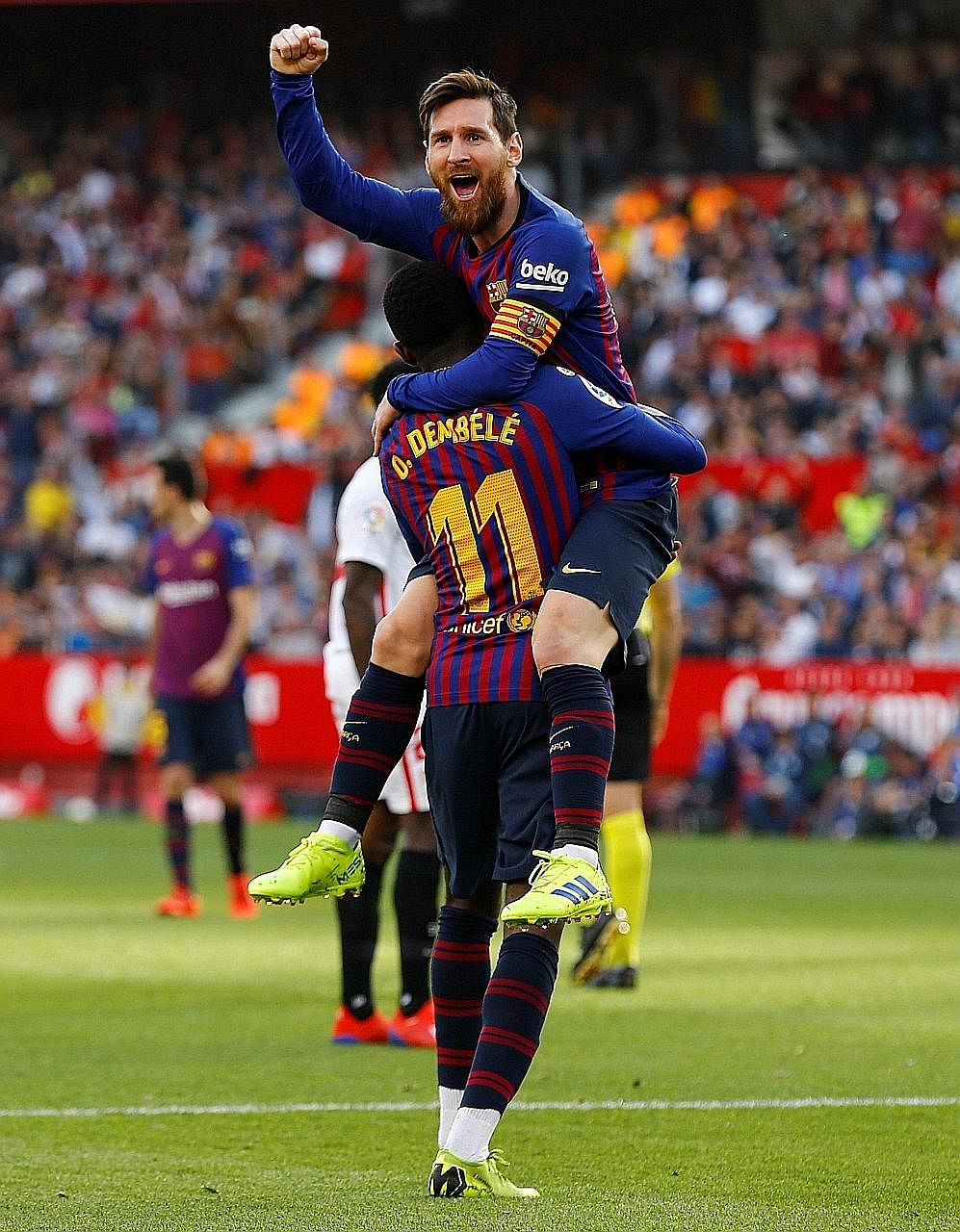 Ousmane Dembele giving Lionel Messi a lift after the Argentinian ace equalised for Barcelona for the second time at Sevilla on Saturday. The Catalans won 4-2 and topped the standings by 10 points before last night's games.