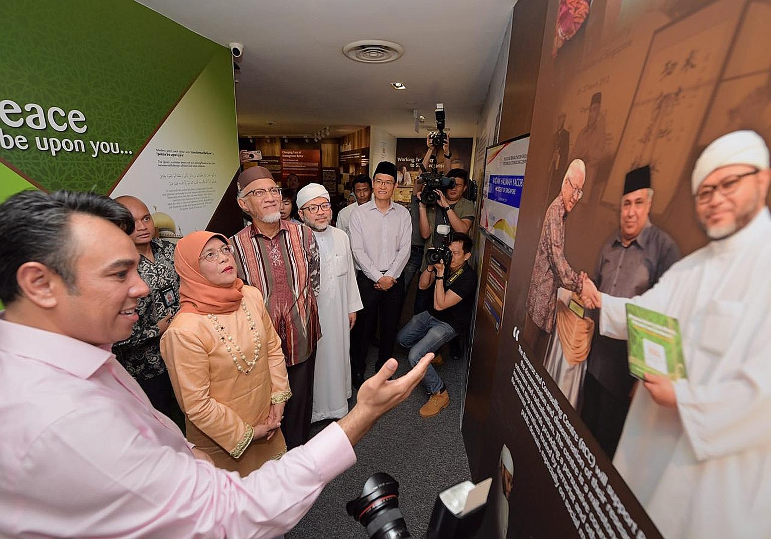 Religious Rehabilitation Group (RRG) vice-chairman Mohamed Ali (left) showing President Halimah Yacob and her husband, Mr Mohamed Abdullah Alhabshee, around the RRG resource and counselling centre at the Khadijah Mosque during their visit yesterday.