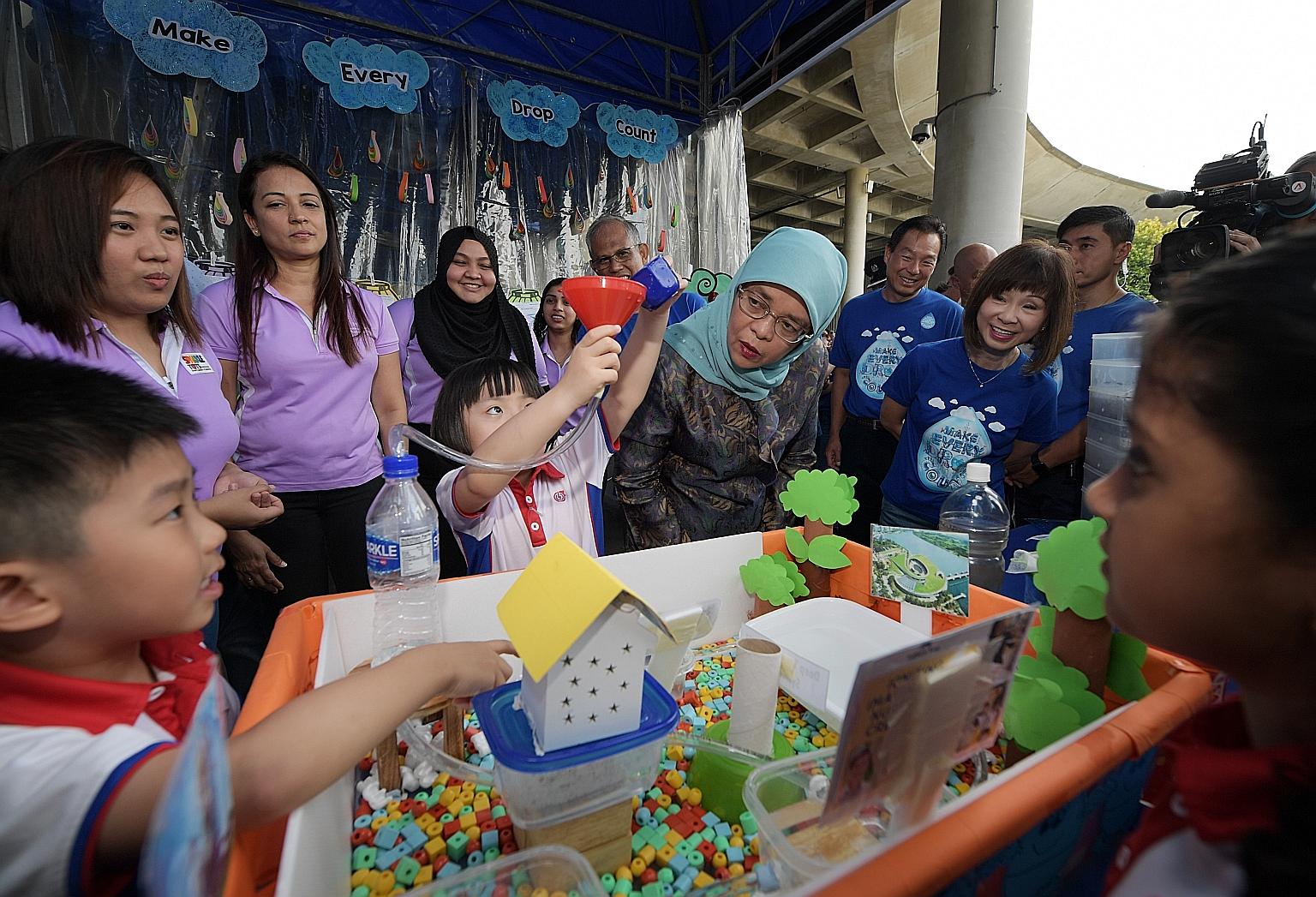 Eadlin Chua, 7, explaining a project to President Halimah Yacob as Environment and Water Resources Minister Masagos Zulkifli, PUB chief executive Ng Joo Hee and Senior Minister of State for the Environment and Water Resources Amy Khor listen on.