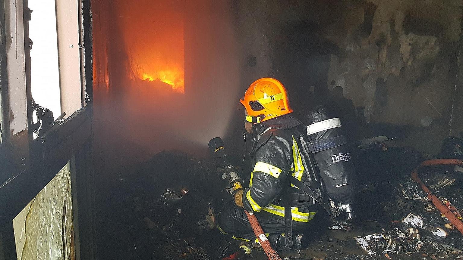 Firefighters wearing breathing apparatus had to forcibly enter the flat. Fire had engulfed the entire unit due to the vast accumulation of combustible items inside, said the Singapore Civil Defence Force.