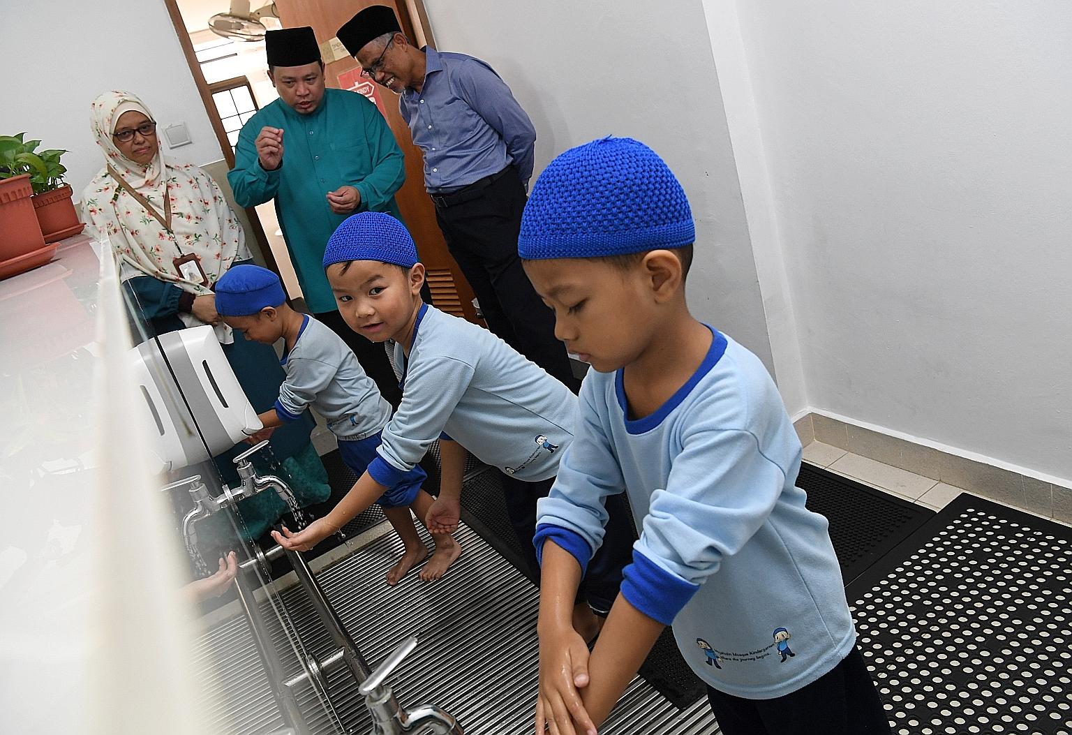 (From far left) Mujahidin Kindergarten principal Nazirah Zainal Abidin, Mujahidin Mosque executive chairman Muhammad Khairul Jameel Yahya and Minister for the Environment and Water Resources Masagos Zulkifli observing kindergarten pupils performing a