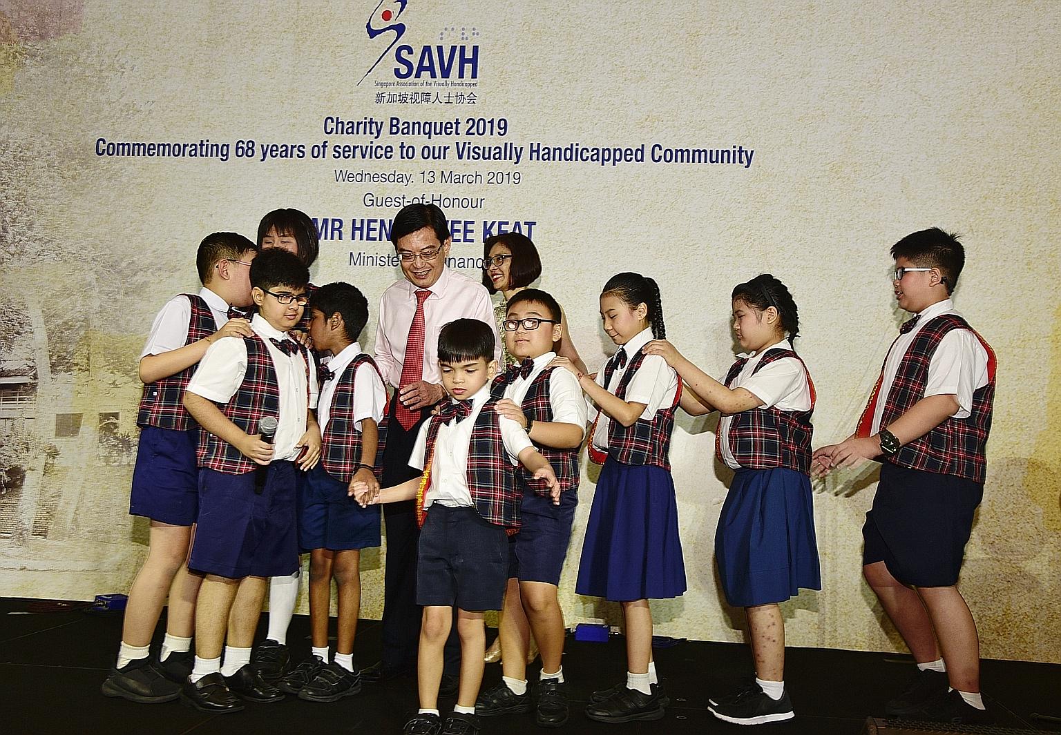 Finance Minister Heng Swee Keat and his wife Chang Hwee Nee with pupils from Lighthouse School, which provides special education to children with visual impairment and hearing loss. The pupils sang at a fund-raising dinner for the Singapore Associati
