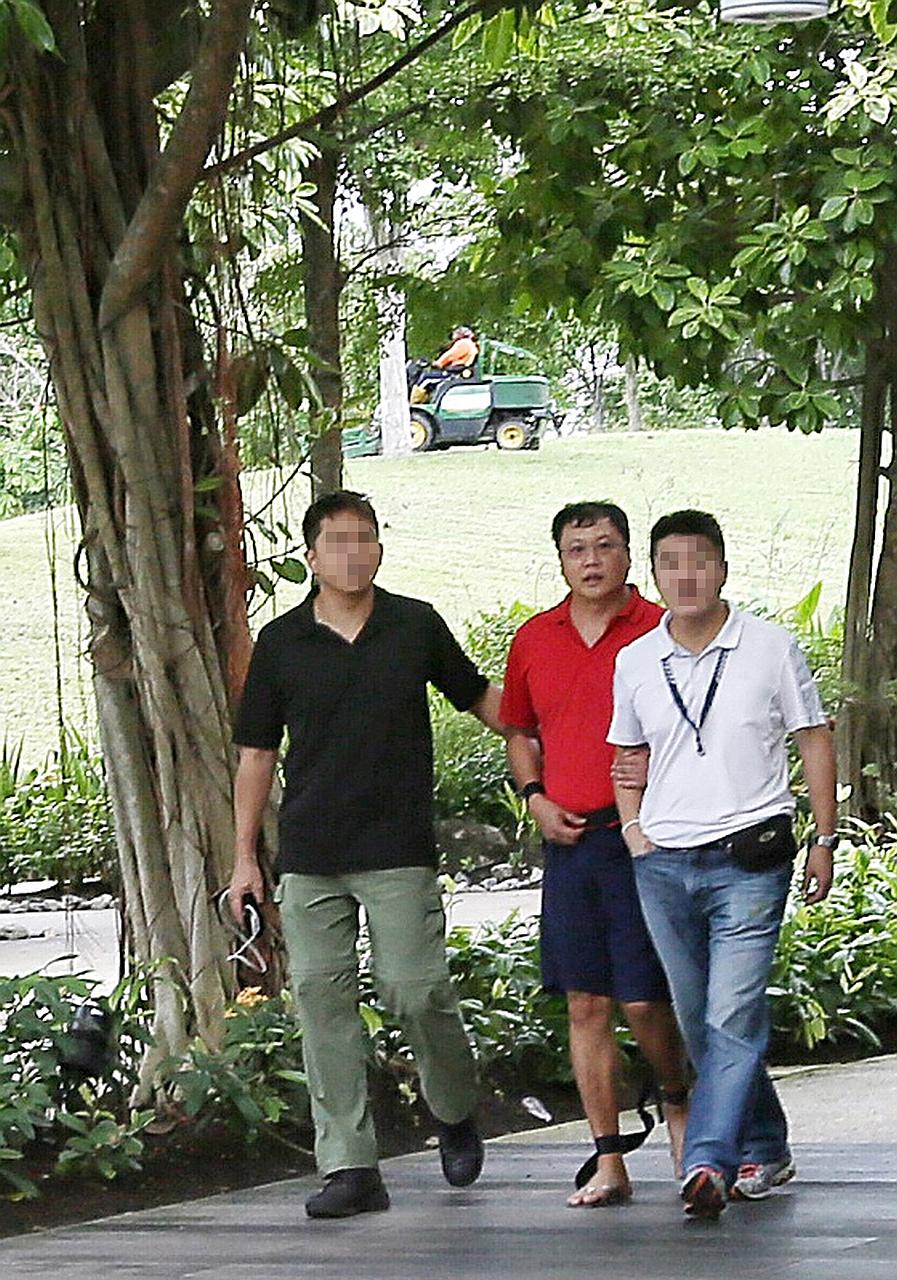 Leslie Khoo Kwee Hock (in red) being taken on July 25, 2016, to Gardens by the Bay, where he was said to have murdered senior engineer Cui Yajie on July 12, 2016.