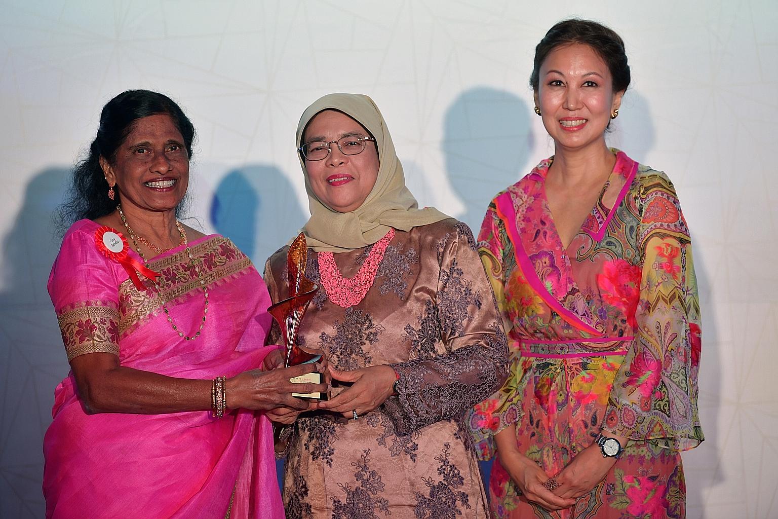 Mrs Glory Barnabas, one of eight new inductees into the Singapore Women's Hall of Fame, receiving her trophy from President Halimah Yacob during last night's ceremony. With them was SCWO president June Goh.