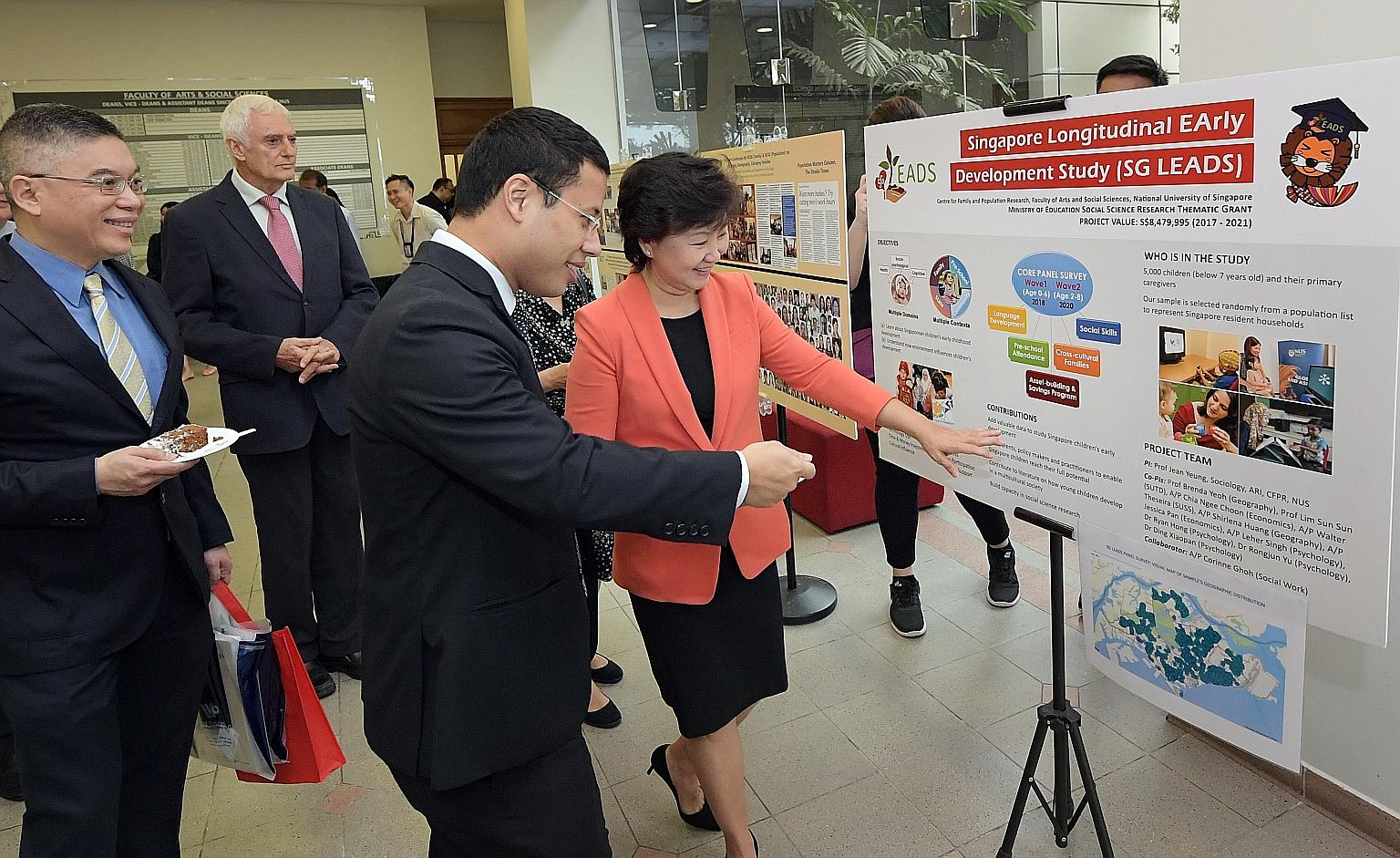 Professor Wei-Jun Jean Yeung, co-director of the Centre for Family and Population Research, and Minister for Social and Family Development Desmond Lee viewing an exhibit featuring the Singapore Longitudinal Early Development Study.