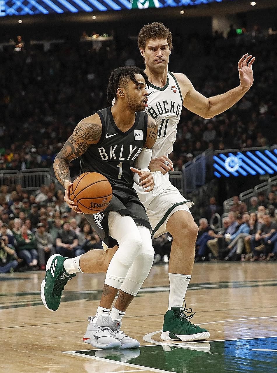 Nets guard D'Angelo Russell driving to the basket against Bucks centre Brook Lopez in Saturday's game which Brooklyn won 133-128.