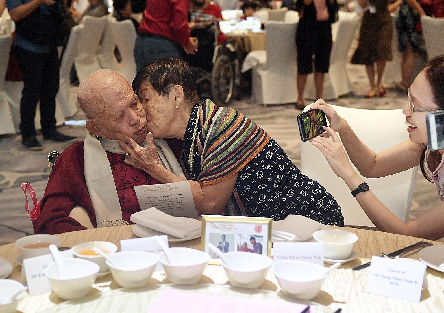 Mr Kang Tian Chan, 88, receiving a kiss from his wife of 57 years, Madam Khoo Swee Tin, who is in her late 70s. They were at the Golden Jubilee Wedding Celebrations, co-organised by the Registry of Marriages and the Registry of Muslim Marriages, yest