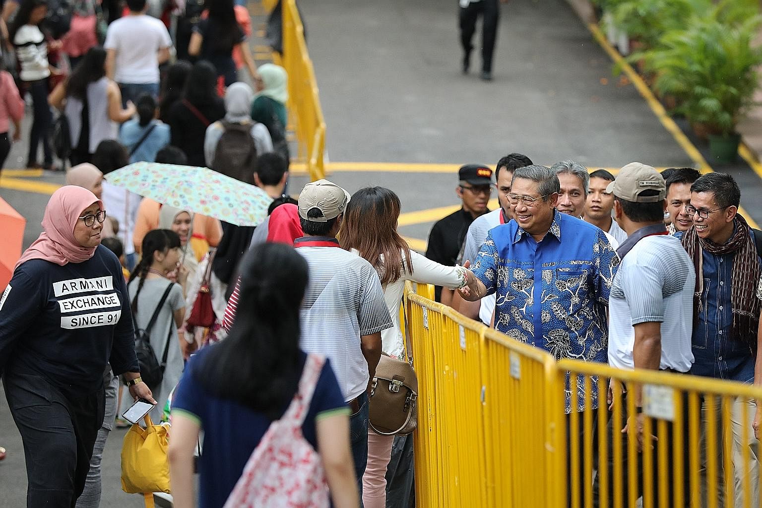 Former Indonesian president Susilo Bambang Yudhoyono arriving at Singapore's Indonesian embassy yesterday for early voting. He stole the limelight when he turned up in the evening, drawing squeals and handshakes.