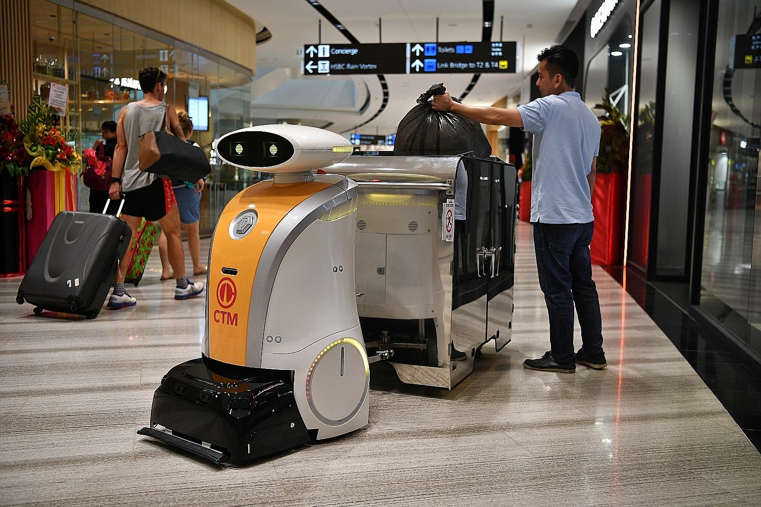 Left: Yi Wei, a robot deployed at Jewel Changi Airport, can pull a 1,000-litre bin along a pre-mapped route. Above: Ella, a scrub robot deployed at the National Gallery Singapore, is fitted with soft brushes for the conserved tiles. ST PHOTOS: CHONG