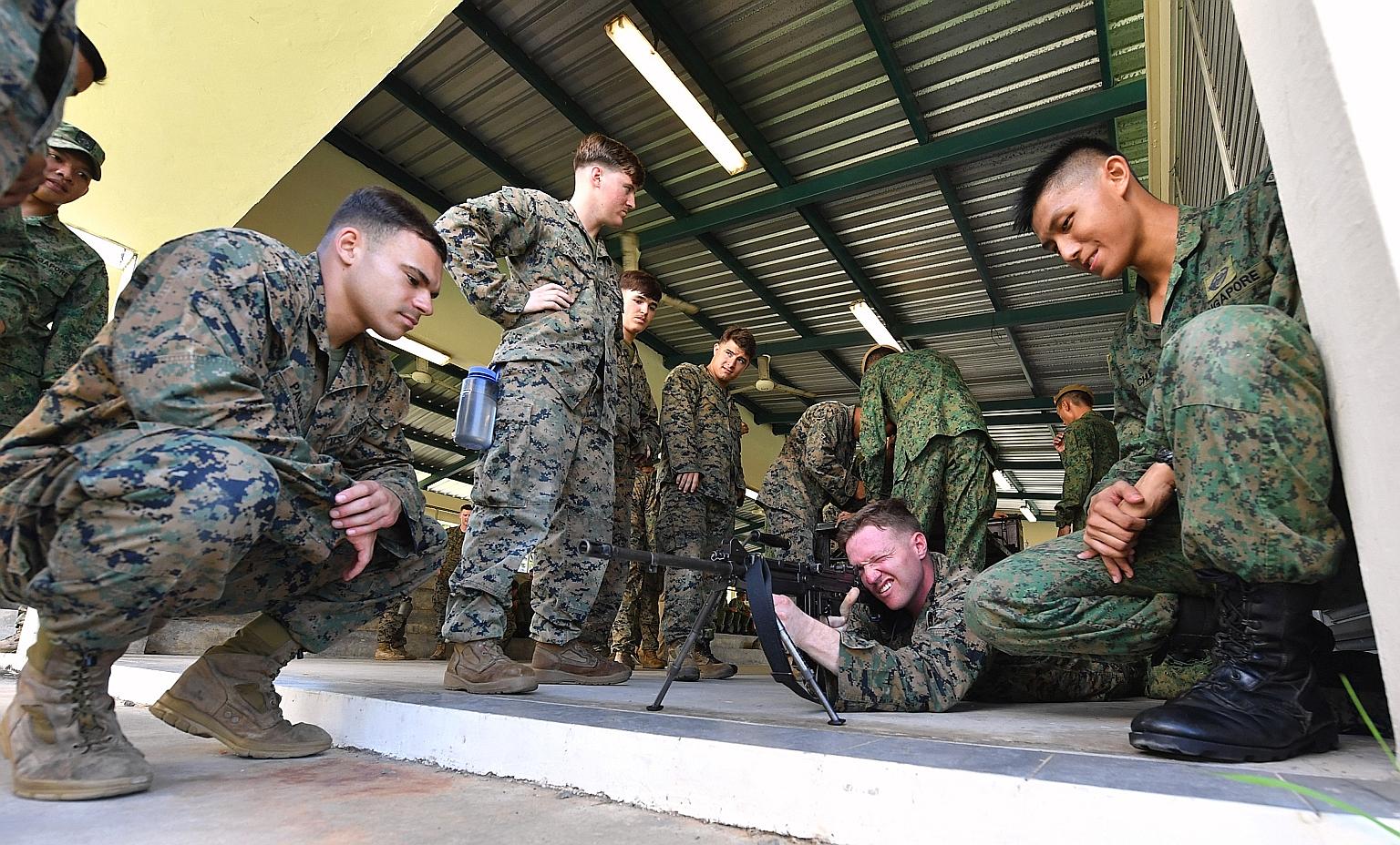 A United States Marine Corps (USMC) soldier trying the Section Assault Weapon as soldiers from the Singapore Armed Forces and USMC look on. This year's annual bilateral exercise is the 23rd time Exercise Valiant Mark is being held, and it will end ne