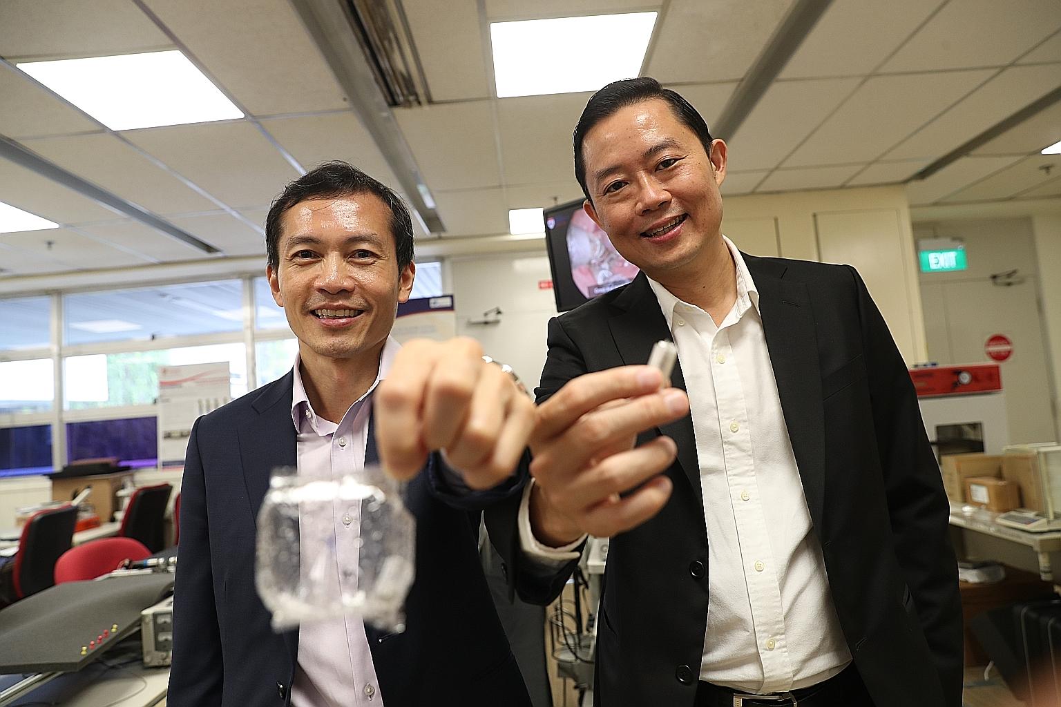 Professor Lawrence Ho (left), clinician-innovator at the National University Health System, with the expanded EndoPil capsule, and Professor Louis Phee, dean of engineering at Nanyang Technological University, with the pre-inflated capsule that is de