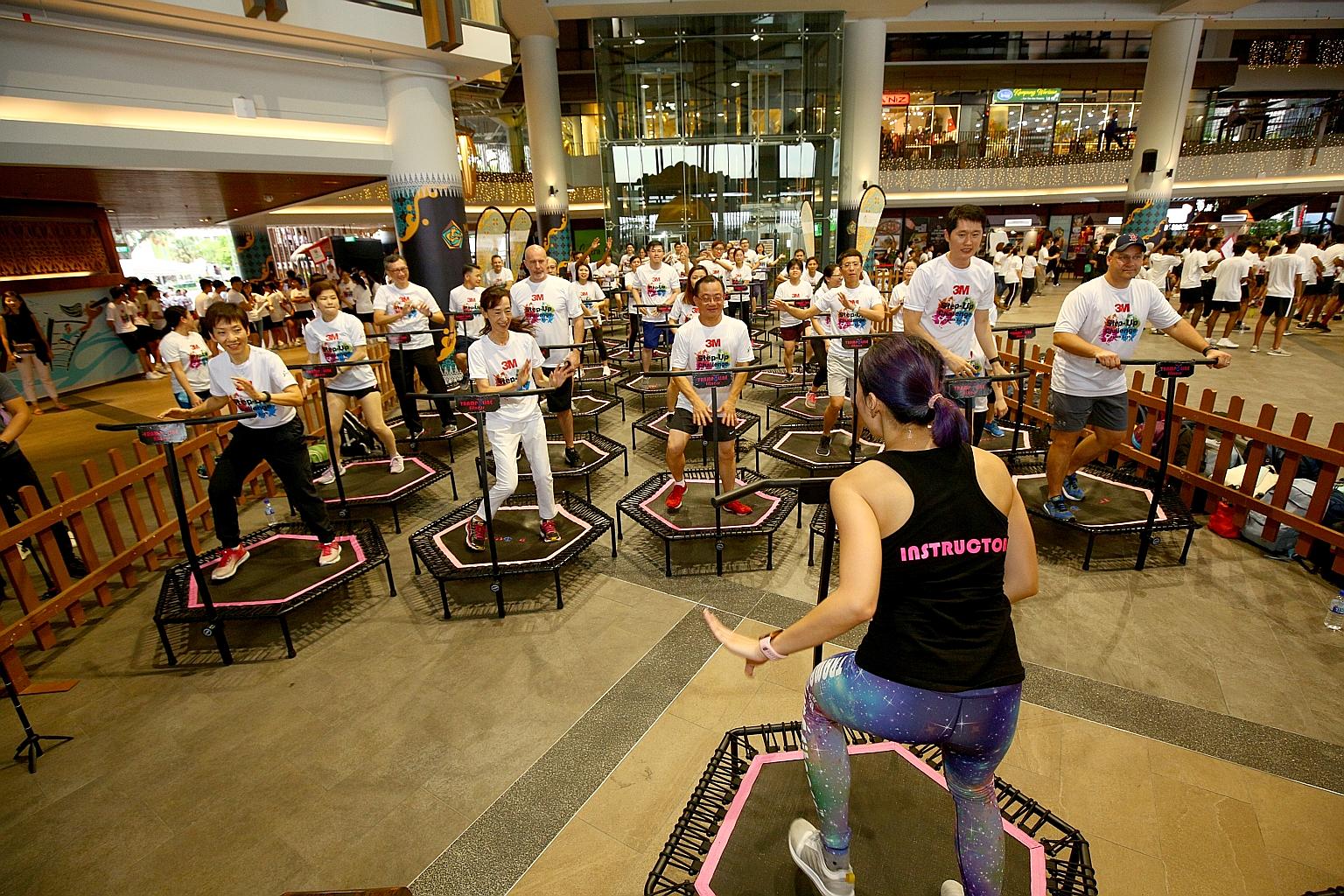 (Front row, from left) Minister for Culture, Community and Youth, Ms Grace Fu, doing a trampoline workout yesterday with managing director of 3M Singapore Yuko Nakahira, vice-chairman of South East Community Development Council Seah Kian Peng, and ot