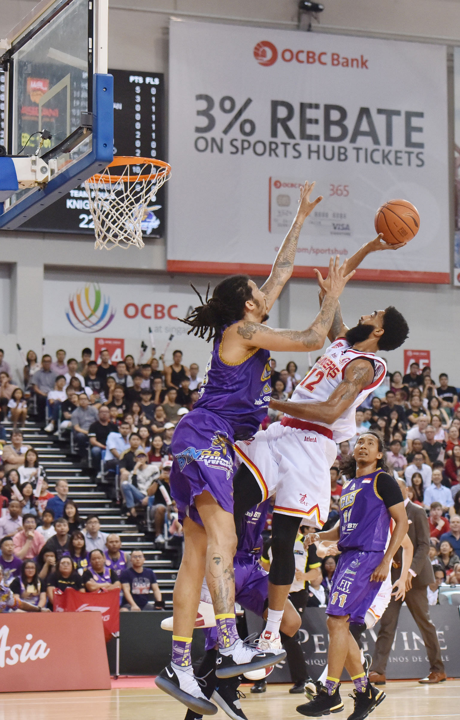 Singapore Slingers' Jerran Young taking a shot while being marked by Maxie Esho of the CLS Knights. ST PHOTO: JASMINE CHOONG