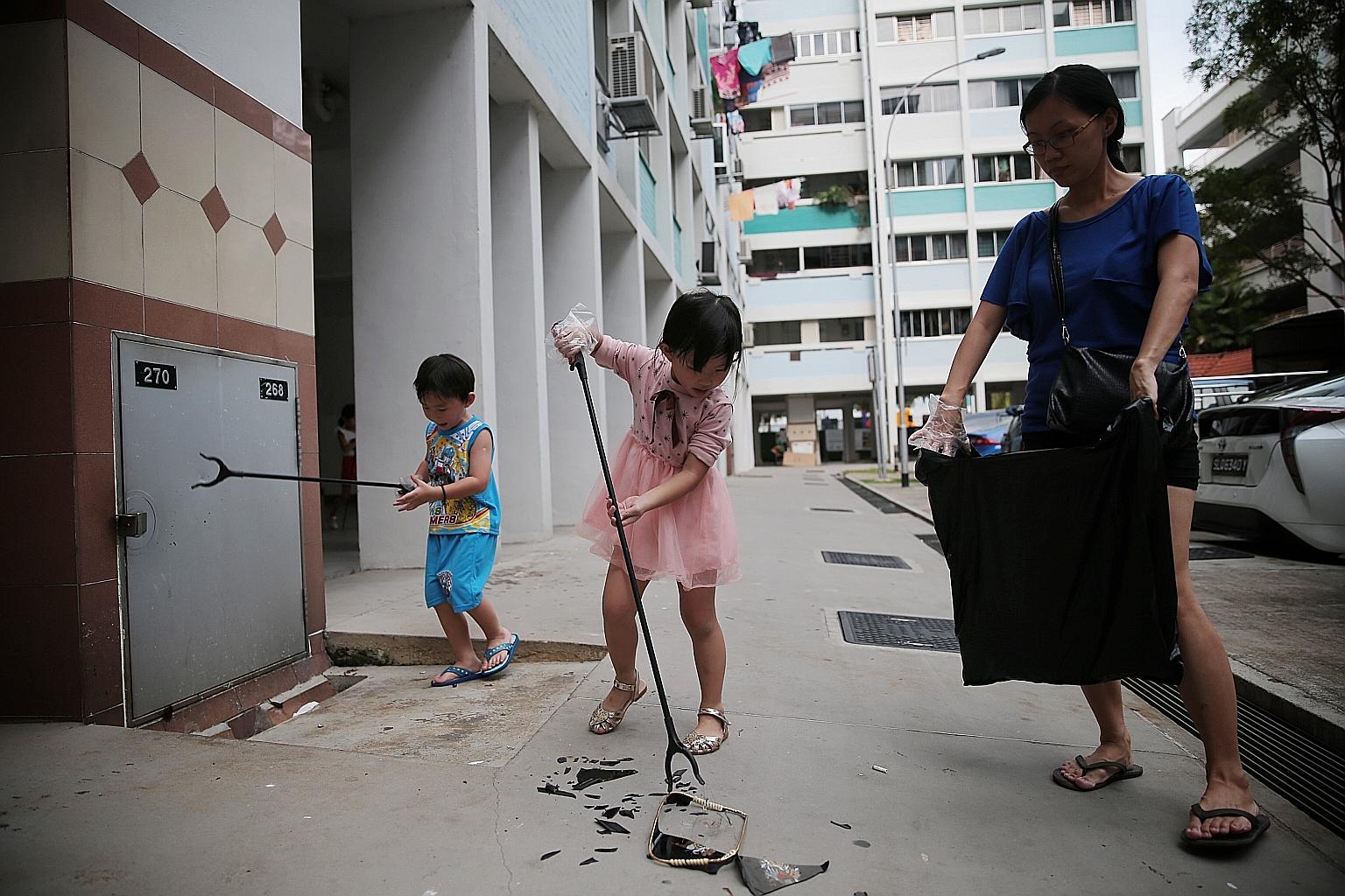 Siblings Aiden Wong, five, (left) and Averie Wong, six, and their mother, Madam Jenny Ong, 39, picking up litter during No Cleaners Day at Nee Soon South yesterday.