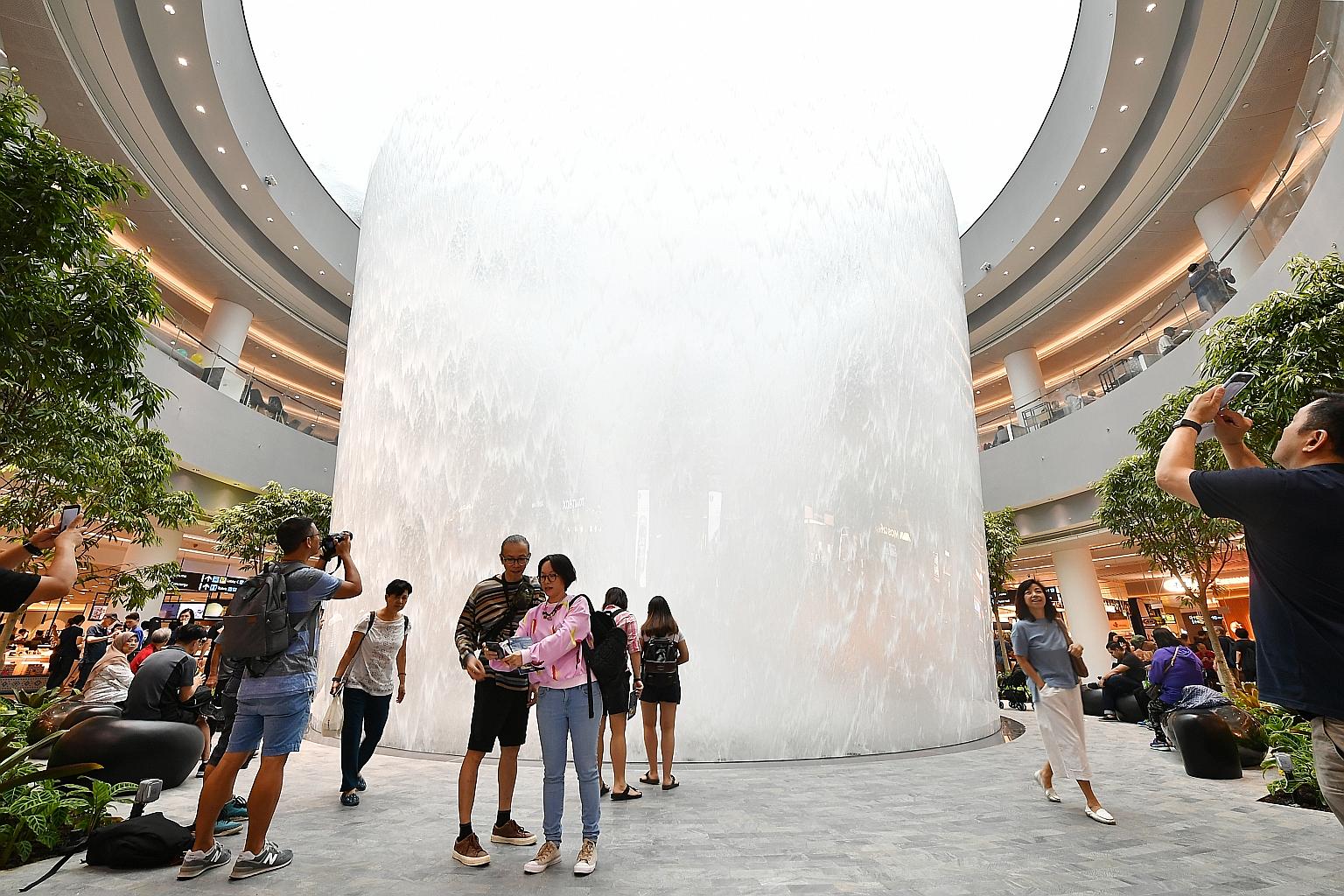 Visitors checking out the indoor waterfall at Jewel Changi Airport, a 10-storey retail complex with passenger check-in services that opened last month.