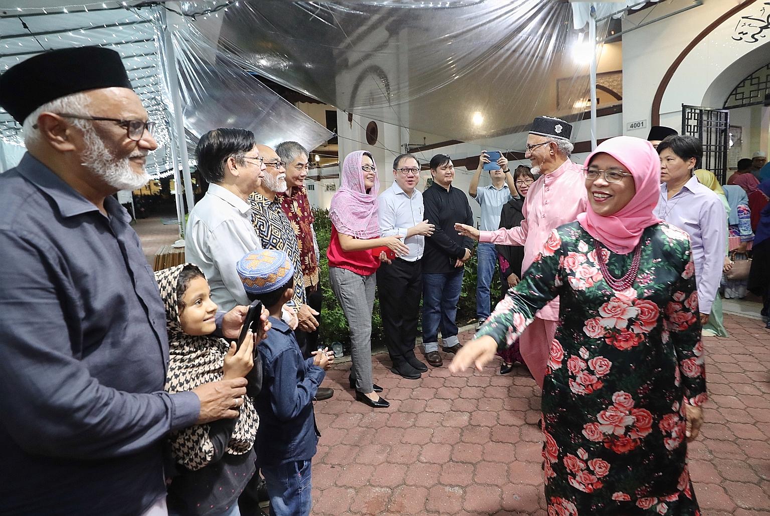 President Halimah Yacob and her husband, Mr Mohamed Abdullah Alhabshee, greeting worshippers at Masjid Hajjah Fatimah yesterday.