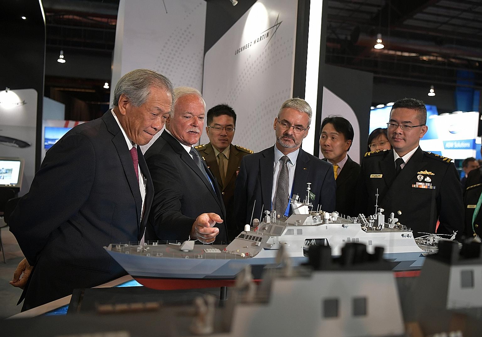 Defence Minister Ng Eng Hen (left), Chief of Defence Force Melvyn Ong (third from left) and Chief of Navy Lew Chuen Hong (right) visiting the Lockheed Martin booth yesterday at the 12th International Maritime Defence Exhibition and Conference Asia. S