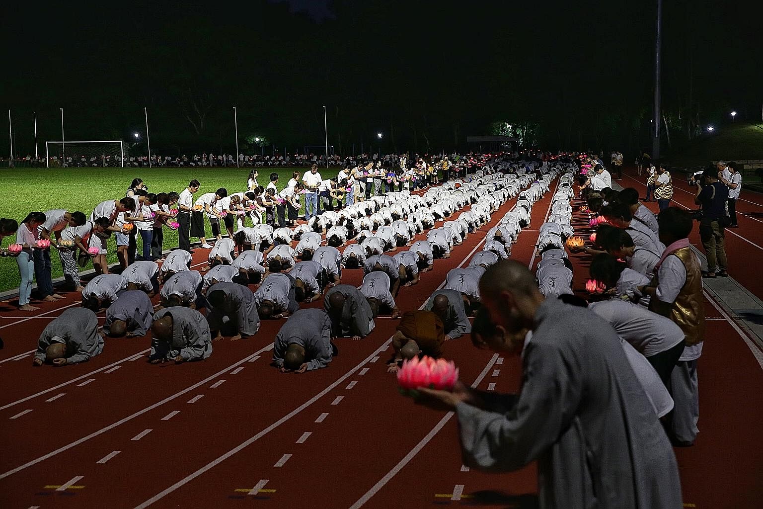 Thousands of Buddhists taking part in the "three steps, one bow" ceremony at the Bukit Gombak Stadium as part of Vesak Day celebrations. The three-hour repetitive sequence is a practice in humility, where Buddhists prostrate mindfully in unison. At t