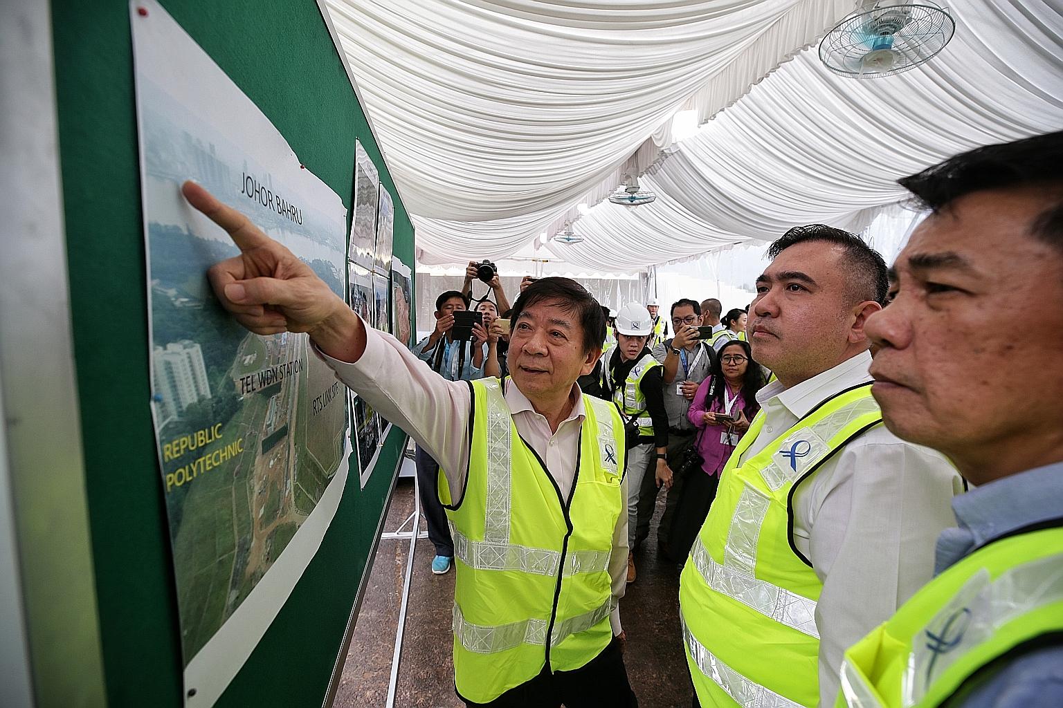 (From left) Transport Minister Khaw Boon Wan, his Malaysian counterpart Anthony Loke and Datuk Mohd Khairul Adib Abdul Rahman, secretary-general of Malaysia's Transport Ministry, looking at an aerial shot of the RTS Link site in Woodlands North yeste