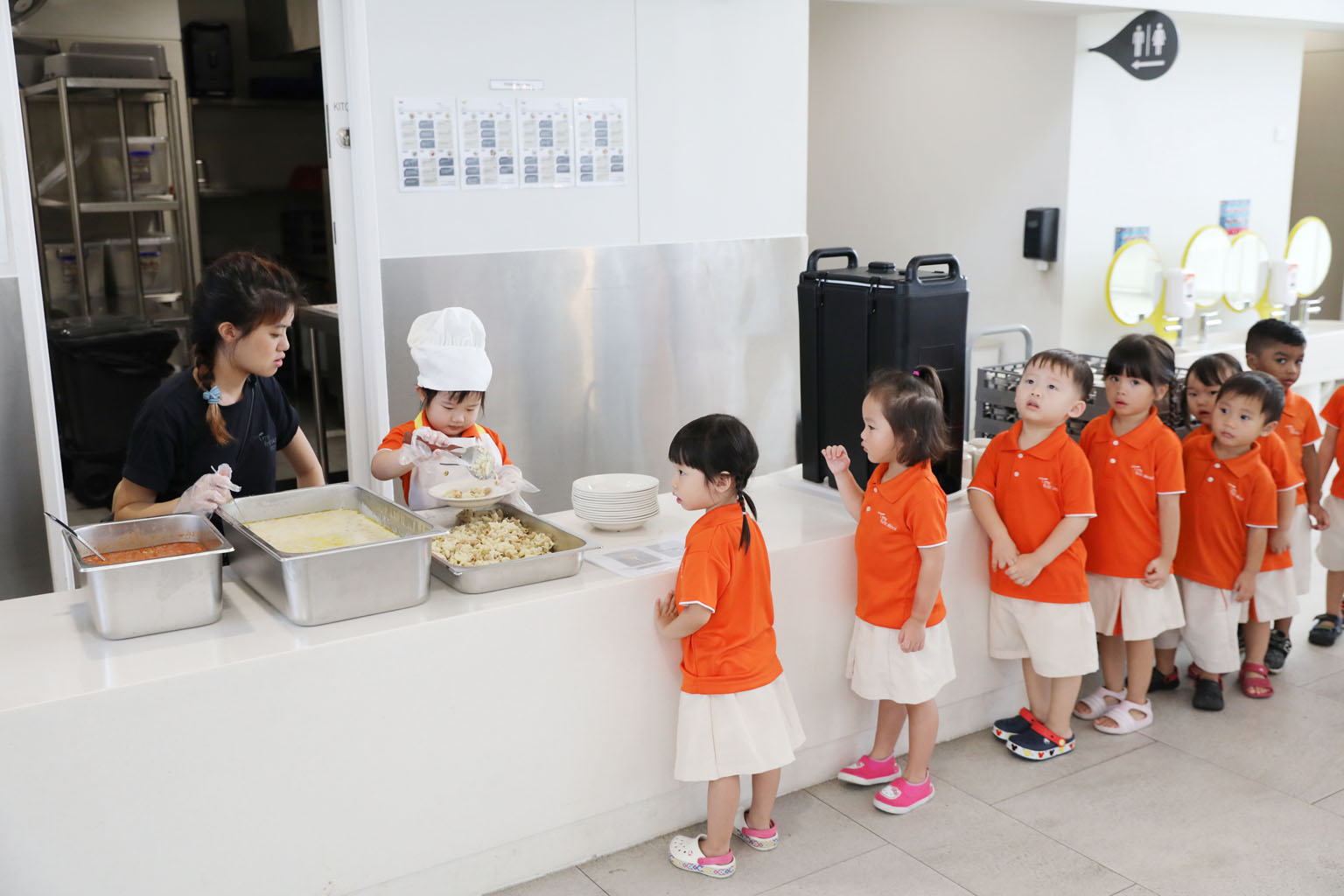 Children waiting to have their meals yesterday at My First Skool's first and largest early-years centre in Punggol Drive. The centre, which was officially opened yesterday, can take in up to 1,065 children and infants. It currently has more than 600 