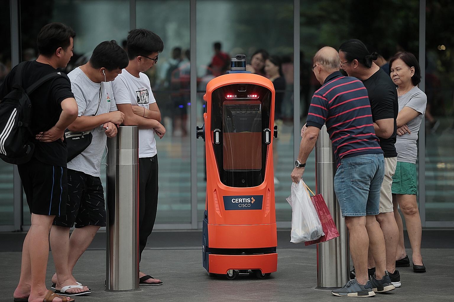 A Certis robot attracting the attention of curious visitors at Jewel Changi Airport yesterday. The robot traffic cop, which is on trial, conducts patrols but does not issue summonses.