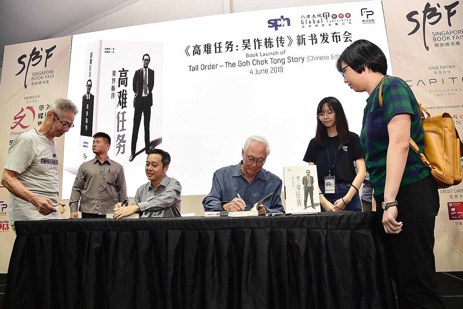 Emeritus Senior Minister Goh Chok Tong signing his book, Tall Order: The Goh Chok Tong Story, for a member of the public at the Singapore Book Fair 2019 yesterday. With him was Mr Peh Shing Huei, who wrote the biography.
