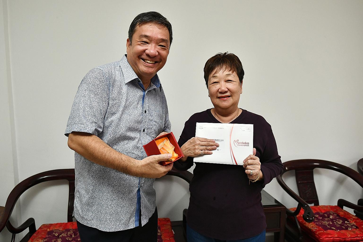 Potong Pasir MP Sitoh Yih Pin giving out Merdeka Generation Package items to Madam Thng Bee Keow, 69, a retired beautician, on Monday. He will make his way through 59 blocks in the next three weeks to deliver the packages by hand. ST PHOTO: LIM YAOHU