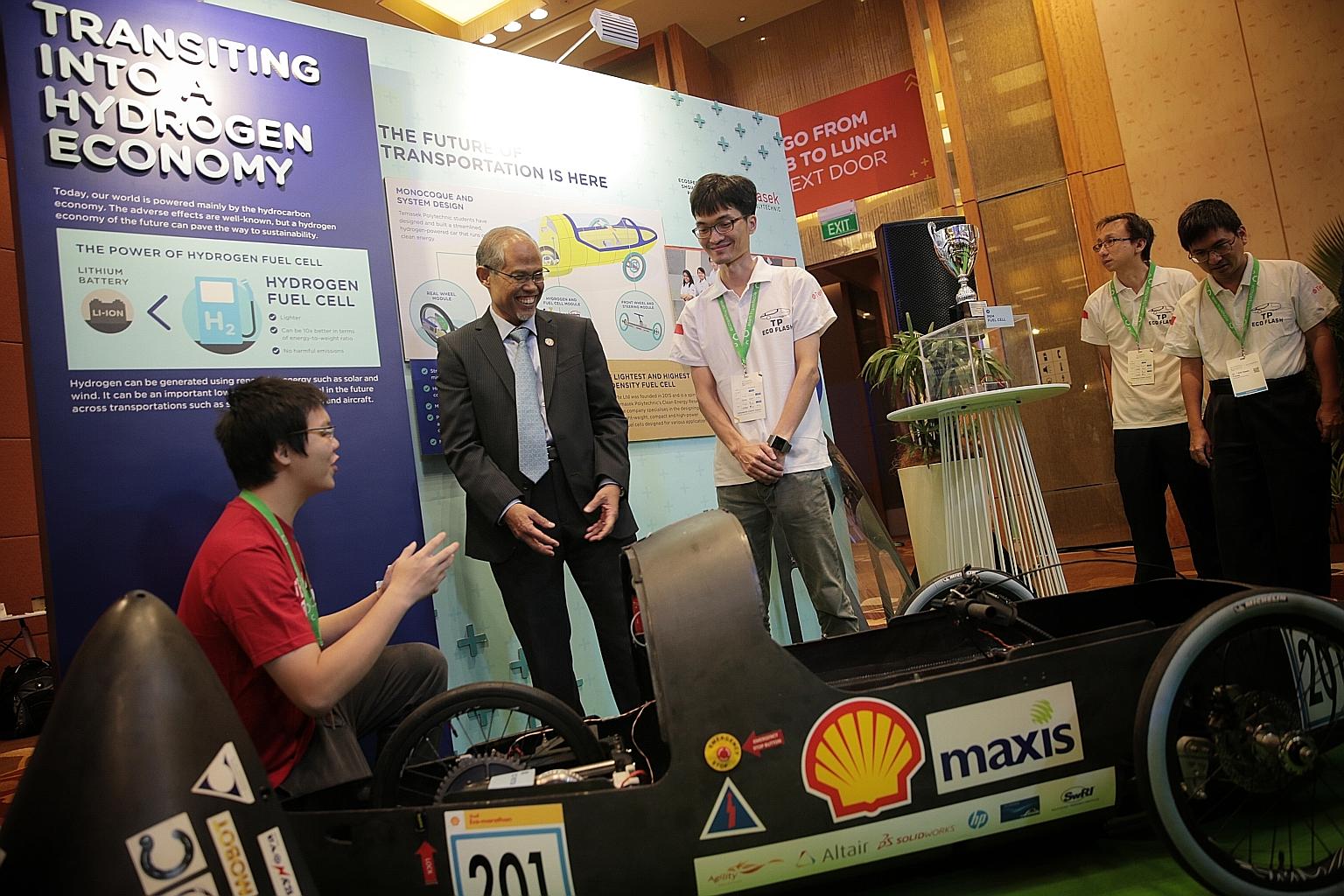 Minister for the Environment and Water Resources Masagos Zulkifli checking out a hydrogen fuel cell eco-car at Temasek Polytechnic's booth at the Ecosperity showcase yesterday. The minister announced the plan for a floating solar photovoltaic system