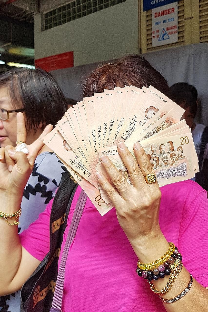Each person is allowed to exchange for up to 20 pieces of the new $20 note in each transaction. Long queues were seen at many bank branches across the island, including the OCBC branch in Toa Payoh Central (above), from early yesterday morning.