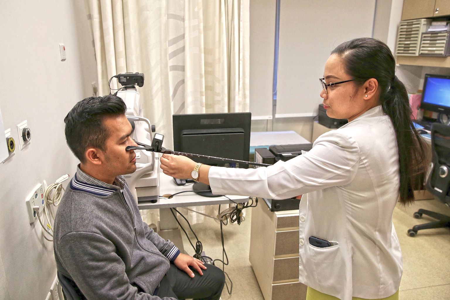 Clinic assistant Eden Joy Ymas yesterday demonstrating the use of a Royal Air Force Rule to conduct a convergence test for double vision in a consultation room used by the Changi Aviation Medicine Centre at Changi General Hospital.