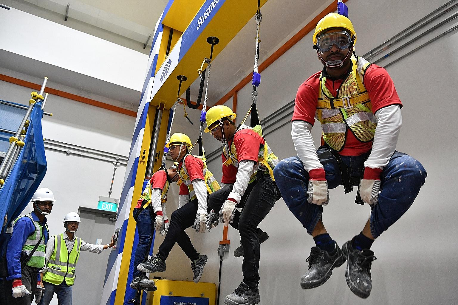 Workers trying out the suspension trauma simulator at the new construction safety school in JTC Space @ Gul. From next month, workers, including supervisors, on all new projects by developer JTC will attend courses at the $2.2 million school. ST PHOT