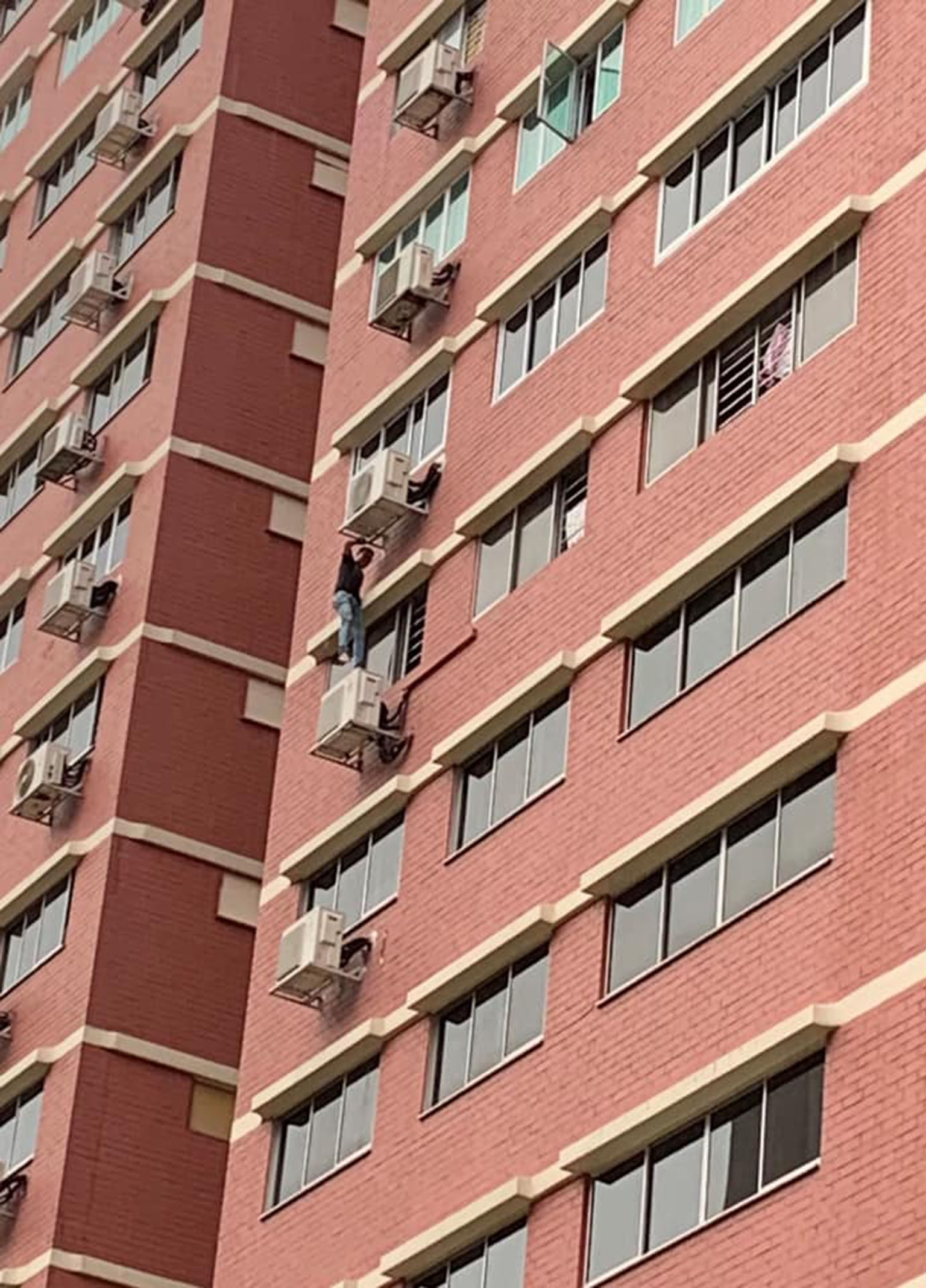 The suspected drug offender climbing down from a 12th-floor flat in Sin Ming Avenue on Thursday. He was later arrested. The Central Narcotics Bureau nabbed 115 suspected drug offenders in an islandwide operation this week.
