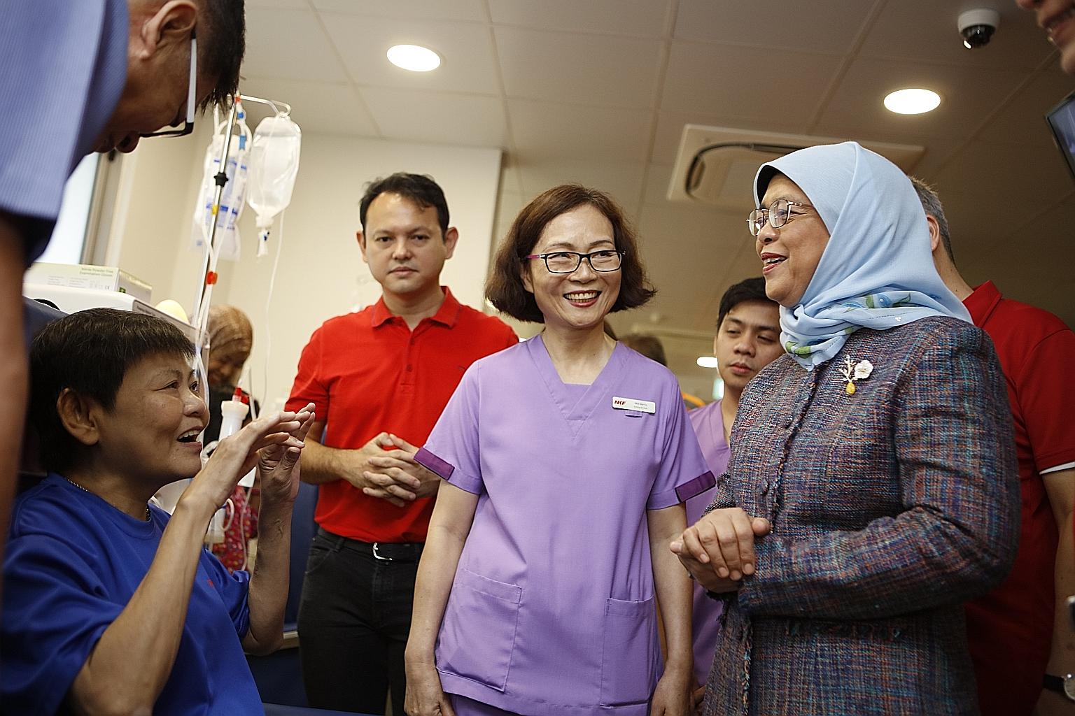 Kidney patient Lau Heng Ing (left) talking to President Halimah Yacob about the convenience of the new dialysis centre. Beside them is Minister of State for National Development and Manpower Zaqy Mohamad.