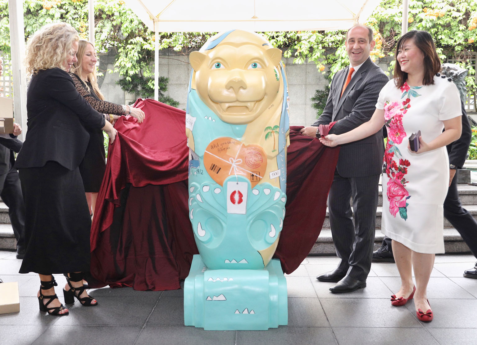 Lion's Pride co-founders Marieke de Zeeuw (front, left) and Diana Francis unveiling the Fullerton Merlion with The Fullerton Heritage general manager Giovanni Viterale and President's Challenge and Community Chest director Priscilla Gan.