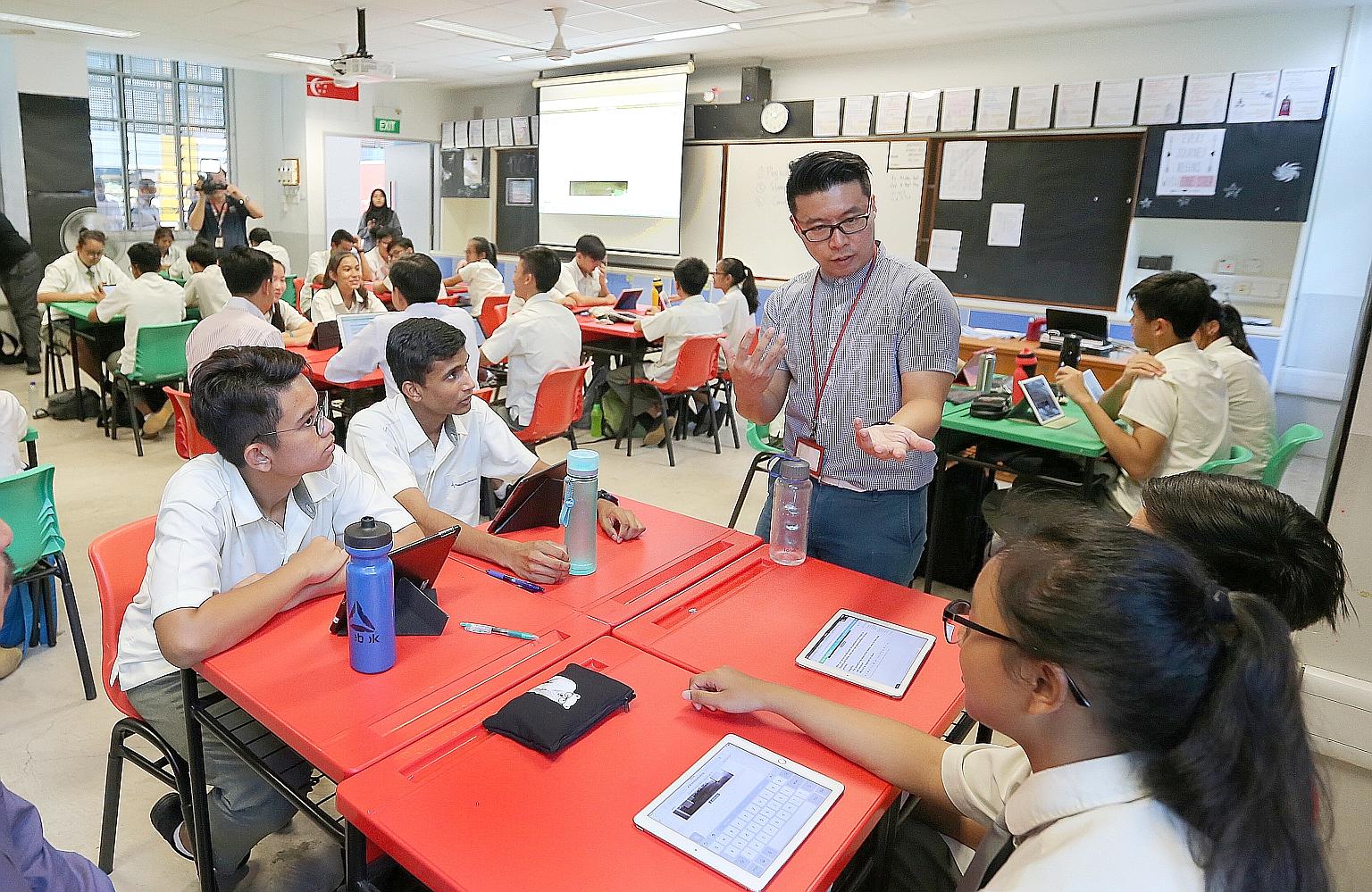 Admiralty Secondary School teacher Tay Peiyong with his students in August 2017. Teachers say they spend less time on administrative work and marking, giving them more time to teach. But they still work more and have less classroom time than many ove