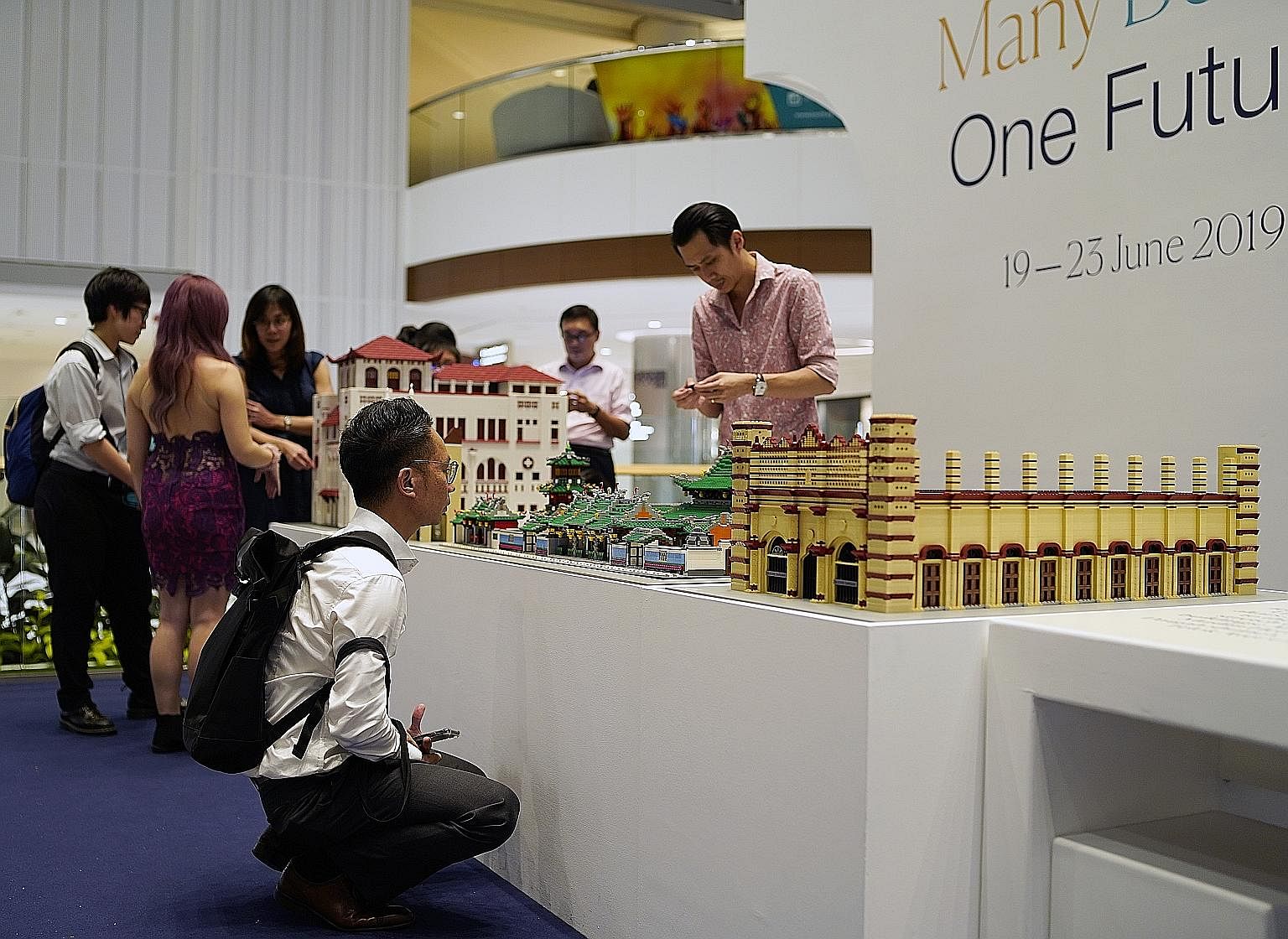 Visitors to an exhibition looking at replicas of religious monuments located in Telok Ayer Street that are built using Lego bricks. The models of the monuments - from far left, Telok Ayer Chinese Methodist Church, Thian Hock Keng Temple and Nagore Da