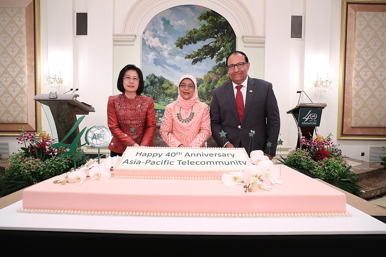 (From left) Asia-Pacific Telecommunity secretary-general Areewan Haorangsi, President Halimah Yacob and Minister for Communications and Information S. Iswaran at the cake-cutting ceremony celebrating the 40th anniversary of the Asia-Pacific Telecommu