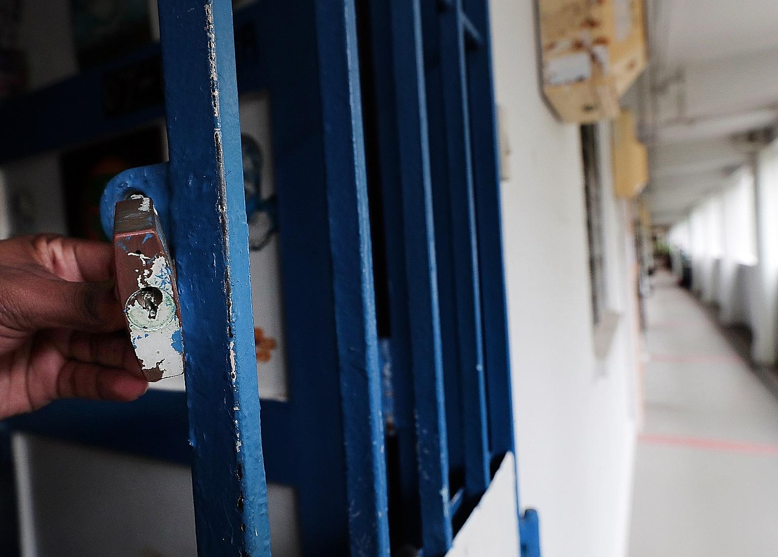 When the housewife lived in Toa Payoh (above), a neighbour said he was once locked inside his flat (left) because someone had stuck something into his padlock. ST PHOTOS: KELVIN CHNG