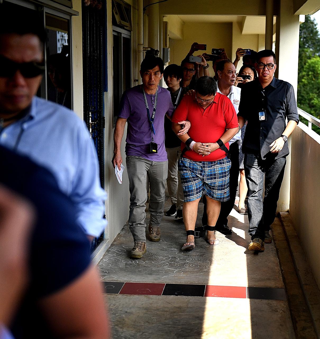 Woodlands double-murder suspect Teo Ghim Heng being escorted by police to his flat at Block 619 Woodlands Drive 52 on Feb 10, 2017. Teo, who was mired in debt, said he decided to end the lives of his pregnant wife and daughter because he did not want