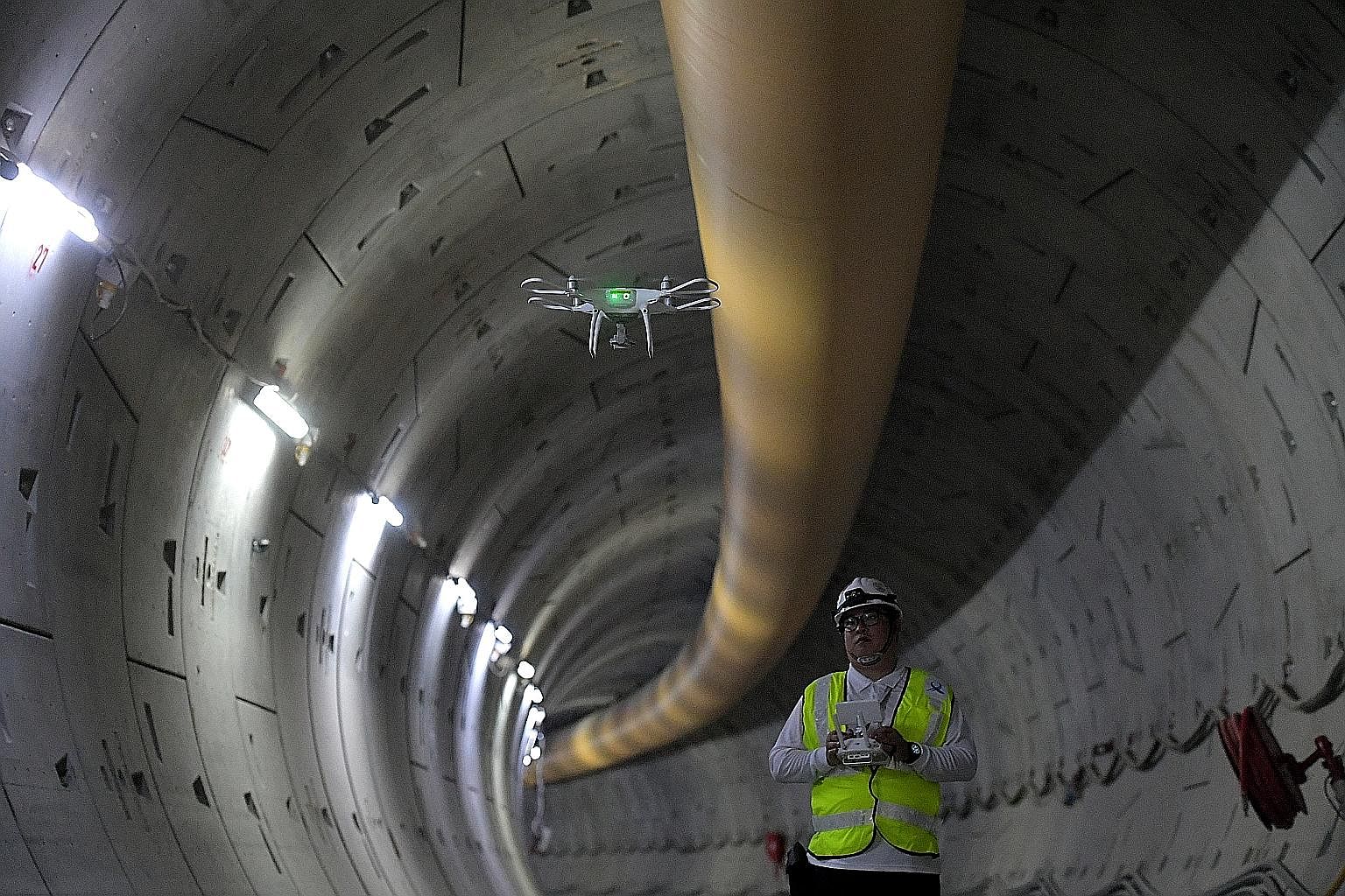 Left: People waiting at the arrival hall of Changi Airport Terminal 2 on June 24. Flight delays on the day were due to drone activity in the area. Below: A drone used to inspect the tunnel of the Thomson-East Coast MRT Line. Drones are used by many g