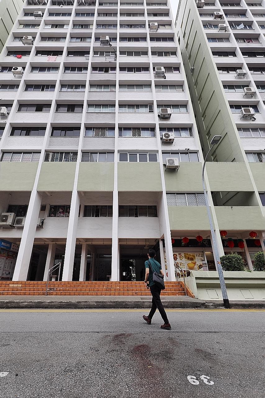 The police found the body of a man's mother in their flat (above) after he was found dead at the foot of their Housing Board block in Little India, where bloodstains (left) can be seen.