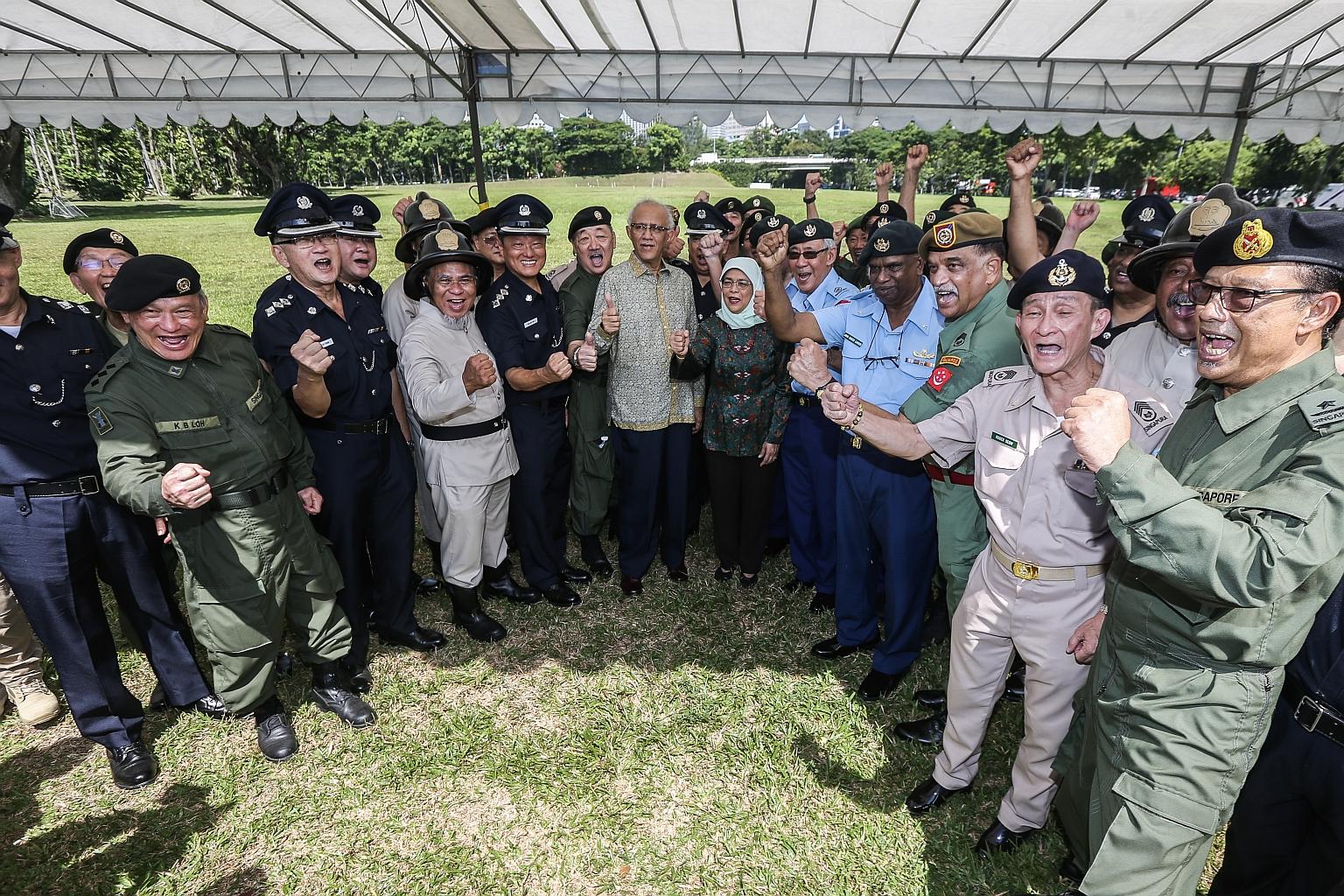 President Halimah Yacob and her husband, Mr Mohamed Abdullah Alhabshee, with servicemen from the Merdeka Generation who are taking part in the mobile column at this year's National Day Parade.