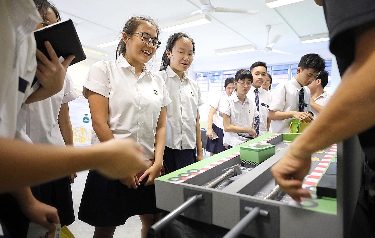 Guangyang Secondary School students playing Race To Save, one of several games organised by the CPF Board at the school yesterday, as part of a programme to motivate secondary and tertiary students to start saving early and learn more about the Centr
