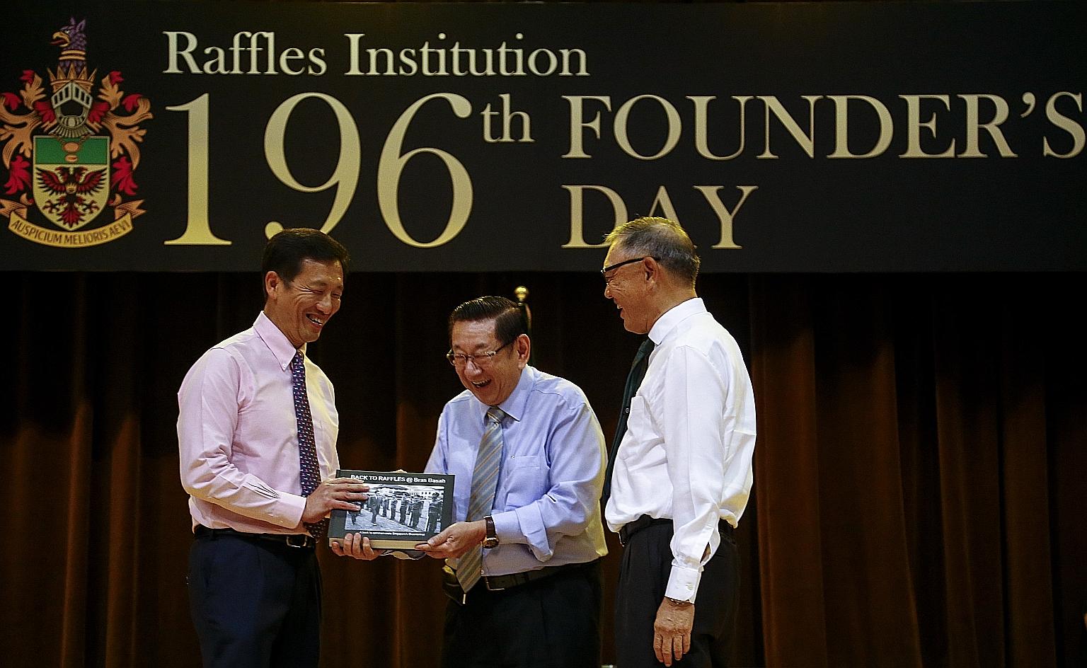 Education Minister Ong Ye Kung being presented the book Back To Raffles @ Bras Basah by Raffles Institution alumnus Er Kwong Wah. Beside them is RI board of governors chairman Choo Chiau Beng.