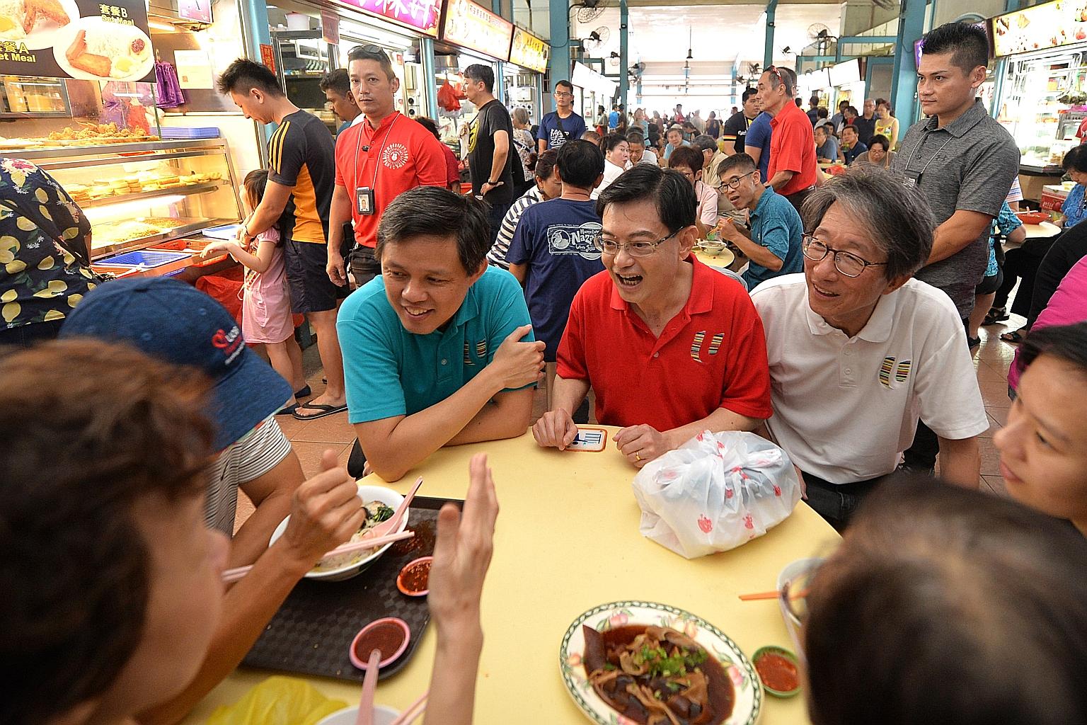 Deputy Prime Minister Heng Swee Keat, flanked by Minister for Trade and Industry Chan Chun Sing (left) and East Coast GRC MP Lim Swee Say, chatting with residents during a ministerial walkabout at The Marketplace @ 58 yesterday. It was the 40th such