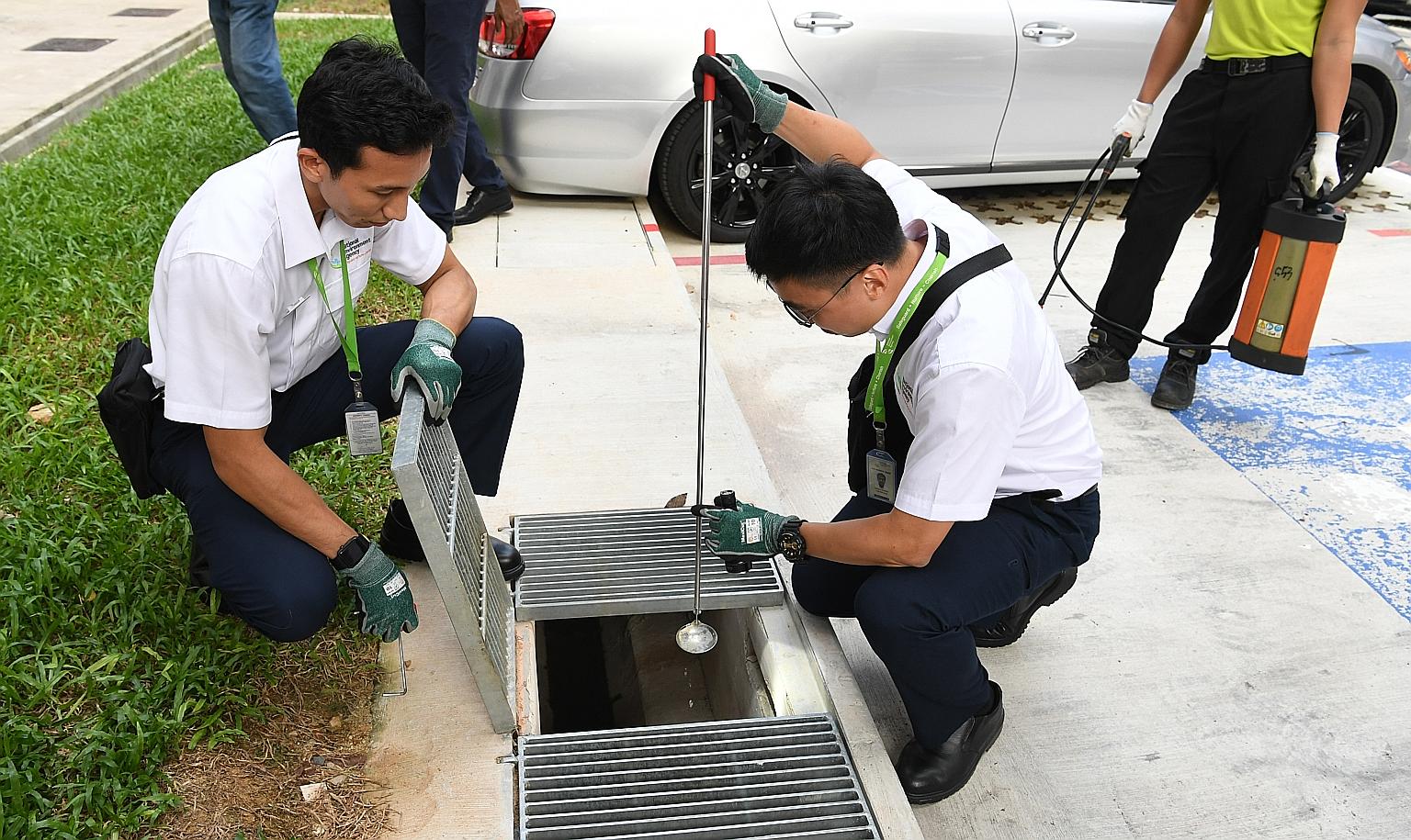 Officers from the National Environment Agency checking for mosquito larvae in Woodlands. As of July 20, nine people in Singapore, including a 46-year-old man, have died from dengue this year. ST PHOTO: KHALID BABA