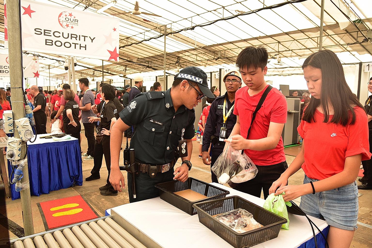 People attending this year's National Day Parade preview at the Padang yesterday having their belongings checked. Security checks will be carried out on everyone entering the venue, including using walk-through metal detectors. Personal belongings wi