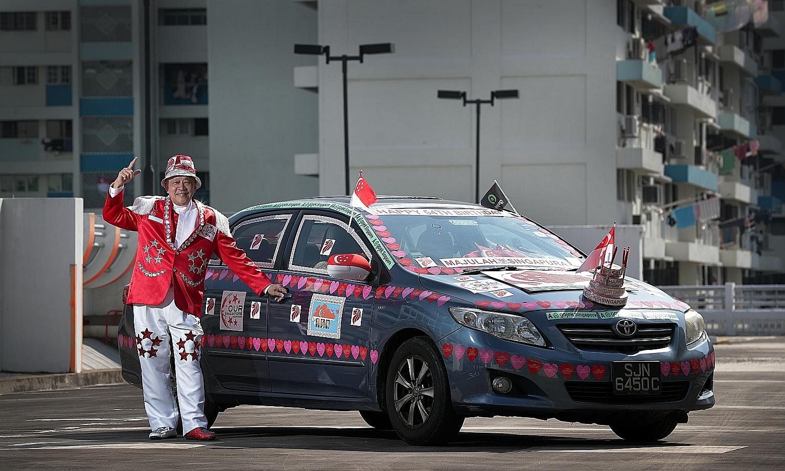 Gojek driver Henry Ho, who has been decorating his car and customising outfits for National Day for more than 10 years, made a birthday cake model to install at the front of his car this year.