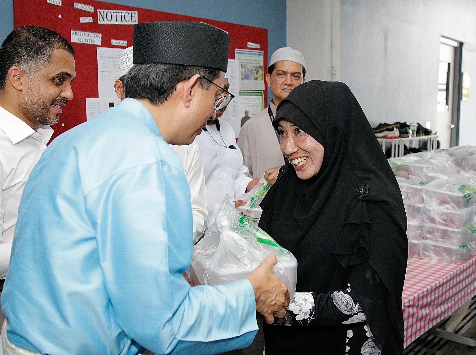 Jamiyah Singapore beneficiary Rahmah Jabbar receiving korban meat from Senior Parliamentary Secretary Faishal Ibrahim at Jamiyah Halfway House (Darul Islah) yesterday. ST PHOTO: JEREMY KWAN